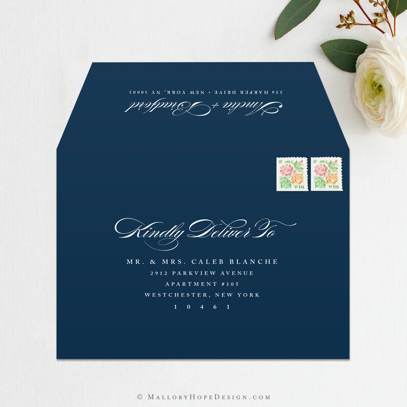 May include: A navy blue envelope with white text that reads "Kindly Deliver To" followed by an address for Mr. & Mrs. Caleb Blanche. The address includes the street name, apartment number, city, state, and zip code. Two postage stamps with floral designs are in the upper right corner.