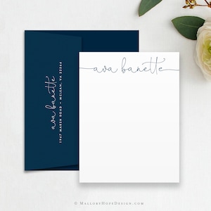 May include: A white stationery card with a navy blue envelope. The card has the name "Ava Barnette" written in cursive at the top. The envelope has the name "Ava Barnette" and an address printed in white.