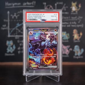 Puede incluir: Una carta coleccionable Pokemon M2 JP Mega Charizard X ex Special Art Rare de 2025 en una funda de plástico transparente. La etiqueta dice 2025 POKEMON M2 JP #110 MEGA CHARIZARD X ex SPECIAL ART RARE GEM MT 10. La carta muestra ilustraciones de dragones.