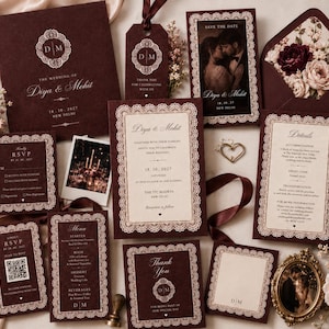 May include: A wedding stationery set in deep burgundy with cream-colored accents and intricate lace-style borders. The collection includes invitations, RSVP cards with QR codes, menu cards, and thank you notes, all featuring the monogram DM and text.