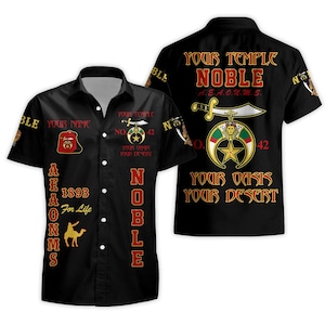 May include: A black short-sleeved button-down shirt featuring red and gold text and graphics. The design includes the text "YOUR TEMPLE," "NOBLE," "A.E.A.O.N.M.S.," "1893," "YOUR OASIS," "YOUR DESERT," and "NO. 42," alongside a camel silhouette and a sword emblem.
