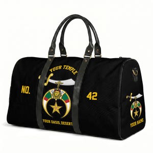 May include: A black duffel bag with black leather-like handles and trim. The bag features a graphic of a scimitar, a pharaoh head, a crescent, and a star. Text reads: NO. 42, YOUR TEMPLE, YOUR OASIS, DESERT, and YOUR NAME on the side panel.