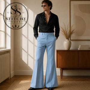 May include: A black long-sleeved button-down shirt paired with light blue high-waisted flared trousers. The shirt features a classic collar and white buttons. The trousers have a structured waistband and a prominent crease down the front legs.