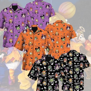 May include: Three short-sleeved button-down shirts featuring a Halloween-themed pattern with Disney characters, spiderwebs, and bats. The shirts are displayed in purple, orange, and black, each with a collar and a repeating graphic print.
