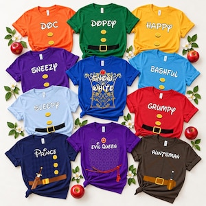 May include: A collection of ten short-sleeved t-shirts in various colors, each featuring character names and costume graphics from Snow White. The shirts display names like Doc, Dopey, Happy, Sneezy, Bashful, Sleepy, Grumpy, Prince, Evil Queen, and Huntsman.