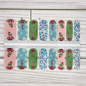May include: A set of 10 Grinch-themed nail wraps featuring a variety of designs, including the Grinch wearing a Santa hat, snowflakes, and glitter.