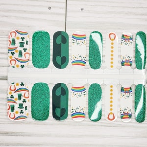 May include: A set of 10 nail wraps featuring a St. Patrick's Day theme. The wraps include green glitter, shamrocks, rainbows, gold coins, and horseshoes.