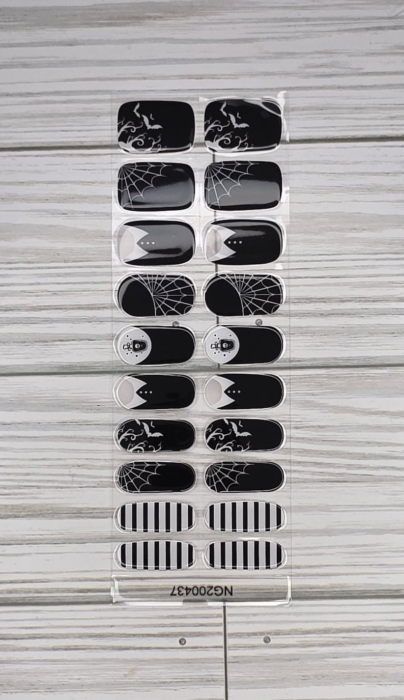 May include: Sheet of black and white nail wraps with Halloween-themed designs. The wraps feature bats, spiderwebs, and striped patterns. The product code "NG200437" is printed at the bottom.