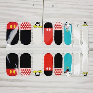 May include: A set of 10 nail wraps featuring a Mickey Mouse theme. The wraps include images of Mickey Mouse's head, his shoes, and polka dots. The wraps are in red, black, white, and blue.