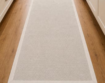 Alfombra de pasillo de sisal color marfil con amplio borde tejido a juego.