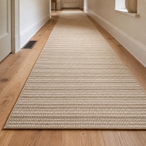 May include: A long, rectangular runner rug featuring a tightly woven, textured surface in neutral beige and tan tones. The rug displays a consistent horizontal striped pattern throughout its length, finished with a clean, bound edge border.
