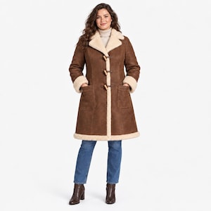 May include: A knee-length brown coat with a cream-colored faux shearling lining and trim. The coat features a wide collar, long sleeves with shearling cuffs, two large front patch pockets, and a front closure with three wooden toggle buttons.