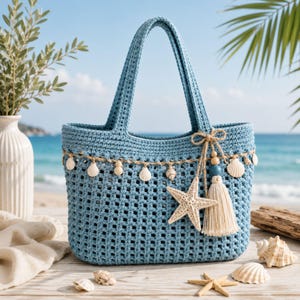May include: A light blue crochet tote bag featuring a grid pattern, adorned with a decorative trim of small white seashells and wooden beads. A large beige starfish and a cream-colored tassel are attached to the side with a jute twine bow.