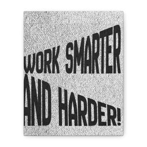 May include: A rectangular wall art piece featuring a textured, light gray, speckled background. Bold, black, sans-serif capital letters are printed across the surface, displaying the phrase "WORK SMARTER AND HARDER!" in a slightly angled orientation.