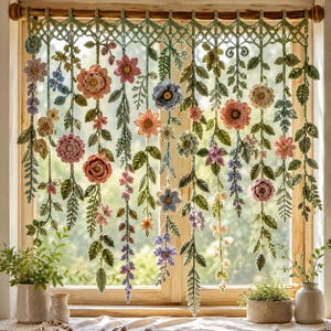Puede incluir: Un colgante decorativo para ventana que presenta una serie de guirnaldas florales de ganchillo suspendidas de una barra de madera. La pieza consta de varias flores de hilo coloridas, incluyendo rosas, azules y crema, intercaladas con hojas de ganchillo verdes.