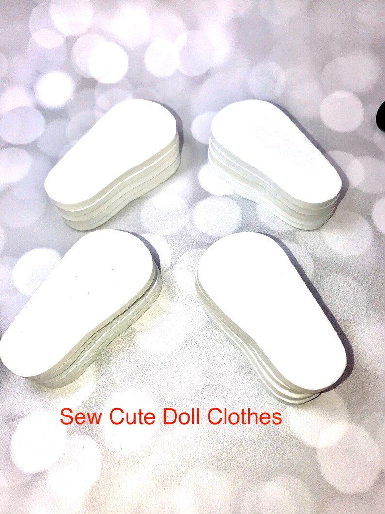 May include: Four stacks of white, oval-shaped doll clothes patterns are arranged on a light, bokeh background. The text "Sew Cute Doll Clothes" is printed in red at the bottom of the image.