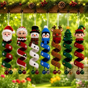 May include: Seven crocheted Christmas ornaments hanging in a row. The figures include Santa, Mrs. Claus, a snowman, a penguin, a reindeer, a Christmas tree, and an elf. Each character features a long, spiraling tail ending in two small jingle bells.