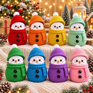 Peut inclure: Huit figurines de bonhomme de neige au crochet disposées sur deux rangées. Chaque bonhomme de neige présente une tête blanche avec un petit nez orange, des yeux noirs, ainsi qu'un bonnet et un corps assortis avec deux boutons noirs. Les couleurs incluent le rouge, l'orange, le jaune, le vert menthe, le vert vif, le bleu, le violet et le rose.