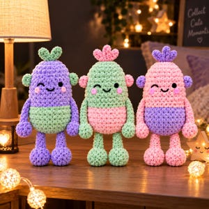 May include: Three crocheted plush figures with rounded bodies, small arms, and legs. The left figure is purple and light green, the center is light green and pink, and the right is pink and purple. Each has a small tuft on top and a smiling face.