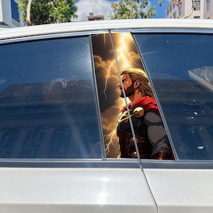 Könnte beinhalten: Ein Autoaufkleber mit dem Seitenprofil eines blonden, bärtigen Kriegers mit rotem Umhang, dunkler Rüstung und Kettenhemdärmeln. Der Hintergrund zeigt einen dramatischen Gewitterhimmel mit hellen, gelben Blitzen in dunklen Wolken.