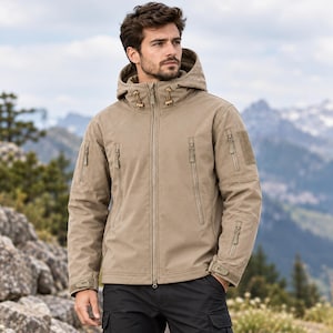 May include: A tan tactical softshell jacket featuring a full-length front zipper, an adjustable hood with drawstrings, two vertical chest pockets, and zippered utility pockets on both sleeves with hook-and-loop patches for identification.