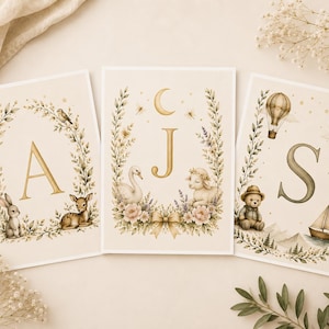 Puede incluir: Tres láminas de arte rectangulares con las letras A, J y S en dorado. Las láminas están decoradas con coronas botánicas, un conejo, un ciervo, un cisne, un cordero, un osito de peluche, un globo aerostático, un velero, estrellas y una luna creciente.