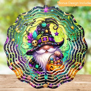 May include: A scalloped-edge metal wind spinner featuring a gnome wearing a witch hat with a skull, holding a pumpkin bucket filled with colorful candies. The design includes a bright green moon, purple stars, and bats against a dark background.