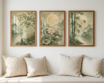 May include: A set of three framed wall art prints featuring landscape scenes in muted green and beige tones. The artwork depicts a tree by a river, a full moon over lotus flowers, and bamboo stalks near water, all enclosed in light wood frames.