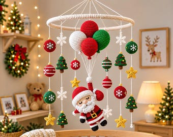 May include: A crochet Christmas mobile featuring a central Santa Claus figure suspended by four yarn balloons in red, white, and green. The mobile includes hanging ornaments shaped like stars, snowflakes, Christmas trees, and spheres with white patterns.