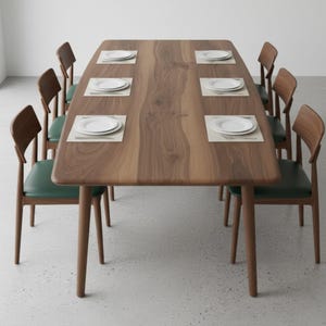 May include: A rectangular wooden dining table with a natural grain finish, accompanied by six chairs featuring dark green upholstered seats and curved wooden backrests. Each place setting includes a white plate on a rectangular placemat.