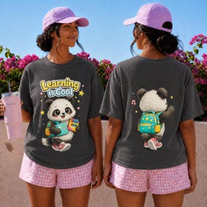 Peut inclure: Un t-shirt gris anthracite avec un panda de dessin animé tenant un livre et des crayons avec le texte Learning is Cool sur le devant, et un panda portant un sac à dos au dos, associé à un short à carreaux rose et une casquette violet clair.