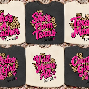 Könnte beinhalten: Sechs Rundhals-Sweatshirts in Creme und Anthrazit, jedes mit einer Grafik der Landkarte von Texas im Leopardenmuster. Die Designs enthalten leuchtend rosa Schriftzüge wie She's A Teacher, She's From Texas, Texas Mama, Rodeo Girl, Y'all Means All und Country Girl.