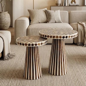 Peut inclure: Un ensemble de deux tables d'appoint rondes présentant un motif à damier sur la surface supérieure dans des tons marron et crème. Les tables ont une base conique avec des rayures verticales alternant bois foncé et tons crème.