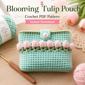 Könnte beinhalten: Ein hellgrünes Häkeltäschchen mit einer Reihe kleiner rosa Tulpenapplikationen, einem weißen Perlenknopfverschluss und dem Text Blooming Tulip Pouch Crochet PDF Pattern Instant Download. Das Täschchen liegt neben mintfarbenem Garn und einer Häkelnadel.