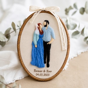 May include: An oval embroidery hoop containing a needle-felted portrait of two figures. One figure wears a blue dress and white veil, the other a light blue shirt and black trousers. The text "Forever & Ever 04.03.2023" is stitched below.