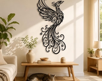 May include: A black wall-mounted metal art piece featuring a stylized phoenix with intricate, swirling filigree patterns throughout its wings and long, flowing tail feathers, displayed vertically on a plain, light-colored interior wall.