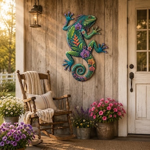 Op de afbeelding: Een wandsculptuur van een leguaan met een kleurrijk patroon van tropische bladeren en bloemen in tinten turkoois, paars, oranje en groen, met een gekrulde staart en gedetailleerde huidtextuur, bevestigd op een verticaal houten oppervlak.