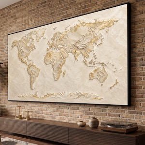 Peut inclure: Une grande œuvre d'art murale rectangulaire représentant une carte du monde texturée en trois dimensions dans des tons crème, beige et or. Les continents sont en relief sur un fond plus clair, le tout encadré par un fin cadre noir.