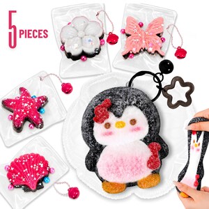 May include: A set of 5 pieces including a black and white penguin keychain with a red bow, and four small charms in clear plastic bags shaped like a white flower, a pink butterfly, a pink starfish, and a pink seashell, all with small bells.