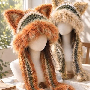 May include: Two fuzzy, crocheted animal-ear hats with long, dangling side panels. The front hat features vibrant orange, green, and cream yarn, while the back hat displays muted yellow, green, and cream tones. Both hats have a shaggy texture.