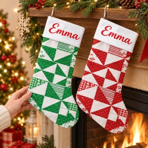 Könnte beinhalten: Zwei Weihnachtsstrümpfe mit weißen Bündchen, auf denen der Name Emma in roter Schreibschrift steht. Ein Strumpf hat ein grün-weißes geometrisches Patchwork-Muster, der andere ein rot-weißes geometrisches Patchwork-Muster. Beide hängen an Haken.