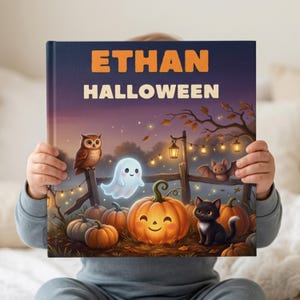 May include: A hardcover book titled ETHAN HALLOWEEN featuring a colorful illustration of a smiling jack-o'-lantern, a small white ghost, a brown owl, a black cat, and a bat in a pumpkin patch at night with string lights hanging on a wooden fence.