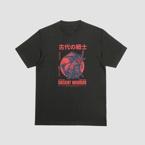 Peut inclure: Un t-shirt noir à manches courtes avec une impression graphique représentant un guerrier samouraï portant un chapeau conique. Le motif comprend un fond circulaire rouge, des caractères japonais et le texte "ANCIENT WARRIOR" en rouge.