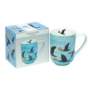 May include: A light blue ceramic mug featuring a repeating pattern of black geese in flight with orange and yellow suns. The mug is displayed next to its matching square cardboard box, which is labelled with the text Niskak Geese Outardes.