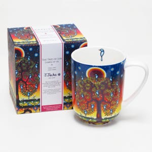 May include: A ceramic mug and its matching box featuring The Tree of Life artwork by J. Jacko. The design displays a vibrant tree with blue birds against a sunset sky, stars, and a sun. A small blue bird is printed on the interior rim of the white mug.