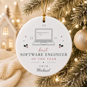 Può includere: Un ornamento rotondo in ceramica bianca con un disegno a linee nere di un computer portatile con codice sullo schermo, circondato da piccoli accenti di agrifoglio rosso e verde. Il testo recita: best SOFTWARE ENGINEER OF THE YEAR 2026 Michael.