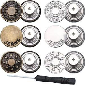 Puede incluir: Un conjunto de seis botones metálicos circulares para vaqueros en tonos bronce y plata, con texto en relieve y motivos de estrellas, junto a un pequeño destornillador con mango negro para su instalación. Incluyen piezas traseras de rosca.