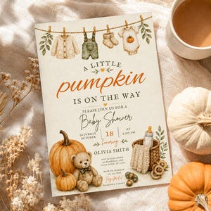 May include: A rectangular baby shower invitation card featuring watercolor illustrations of baby clothes on a clothesline, a teddy bear, pumpkins, and a basket. The text reads A LITTLE PUMPKIN IS ON THE WAY, PLEASE JOIN US FOR A BABY SHOWER, and event details.