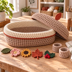 May include: A round, lidded crochet basket in beige and cream with a rust-colored accent stripe. The lid features a single crochet leaf. Accompanying the basket are two small crochet rings and five decorative appliques: a leaf, flower, sunflower, maple leaf, and holly berries.