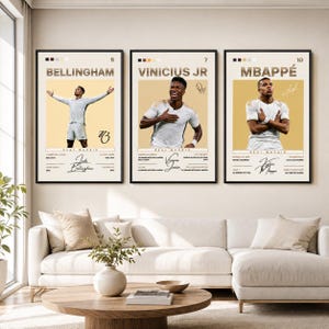 Peut inclure: Un ensemble de trois affiches encadrées représentant les joueurs de football Bellingham, Vinicius Jr et Mbappe. Chaque affiche montre un joueur en maillot blanc, son nom, un numéro, une signature et des détails sur ses accomplissements.